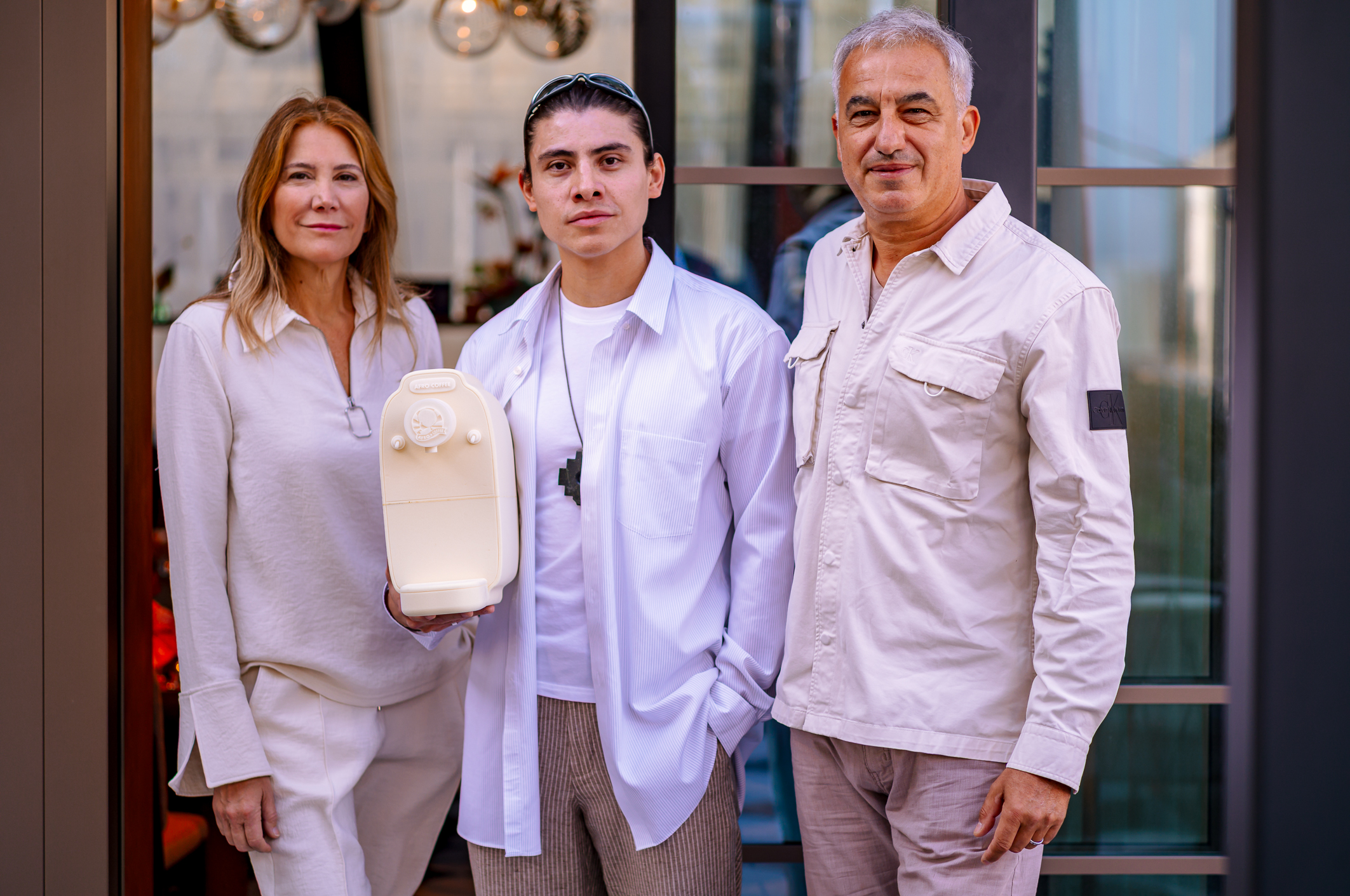 Drei Personen mit einer Afro Coffee Kahawa Kapselmaschine.