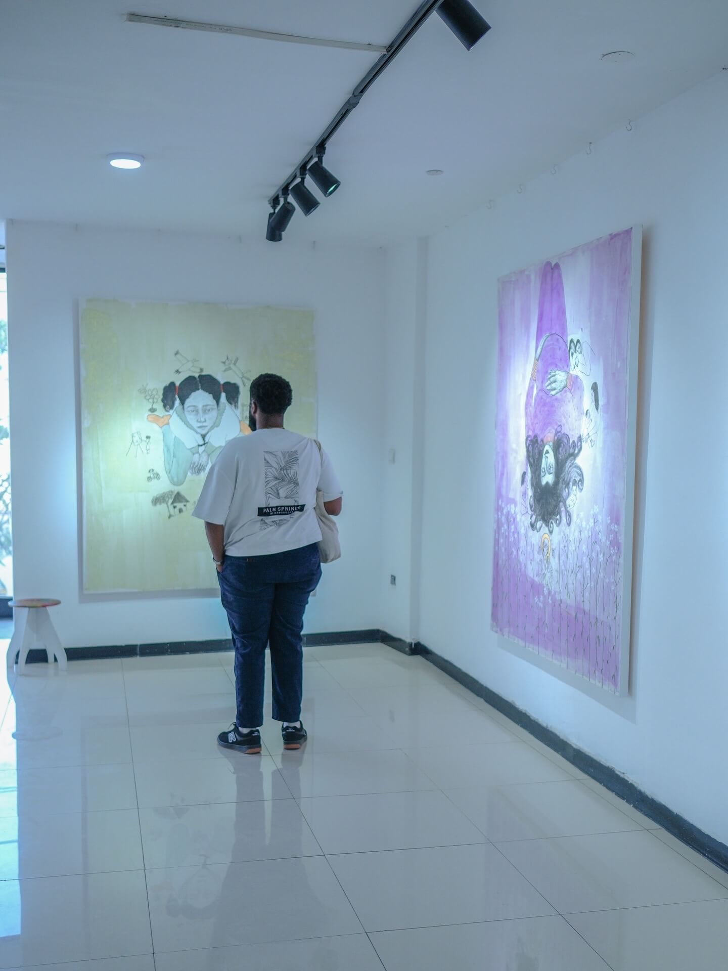 Eine Person betrachtet Gemälde in einer Galerie.
